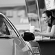 Customer being handed an order at the drive-thru window by an employee